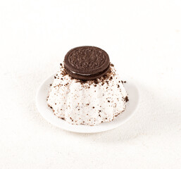 Creamy pudding with chocolate vanilla cookies on a plate on a white background