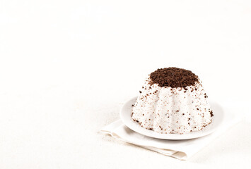 Italian dessert panna cotta with chocolate chip cookie crumbs on a plate on a white background copy...