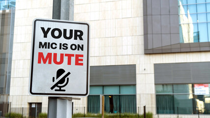 Your mic is on mute sign in a downtown city setting