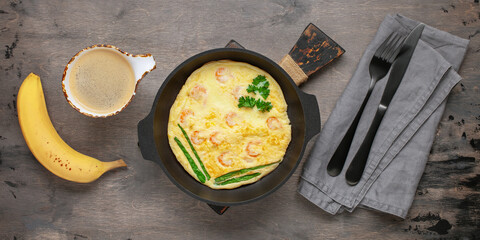 Healthy breakfast - omelette with shrimp, coffee and banana on the table. Top View