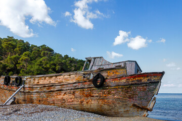 Fototapeta na wymiar Old wooden boat, aged and abandoned at a secret shore at Skyros island, Sporades islands, Greece, Europe