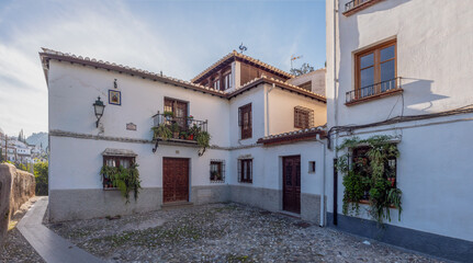 street in the old town of Granada with flowers in the windows at sunset in the Albaicin, Granada, Spain