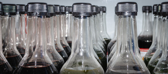 Glass bottles with lids and dark liquid. Drying oil, paint.