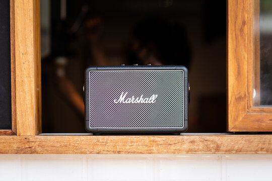 Thailand - March 2021 ; A "Marshall" musical Bluetooth audio speaker in classic vintage design, It placed on the window knob of the retry style cafe.