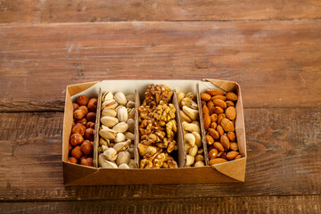 Assorted nuts in packaging on a brown wooden table. Copy space