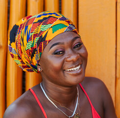 Happy African woman in the small village of Keta located in Ghana, dressed in African headdress