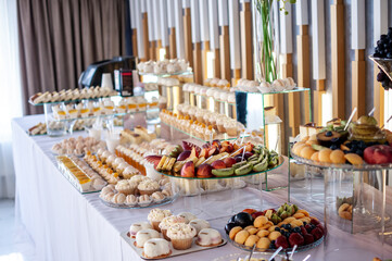Sweet cakes at a wedding banquet. Catering, sweet festive buffet. Candy bar