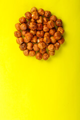 Peeled hazelnuts scattered on a yellow background. copy space.