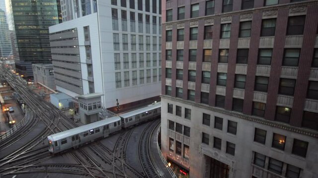 Lockdown shot of metro train on bridge amidst buildings in city - Chicago, Illinois