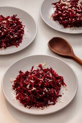 Grated baked beetroot and grated raw horseradish salad on a gray plate.