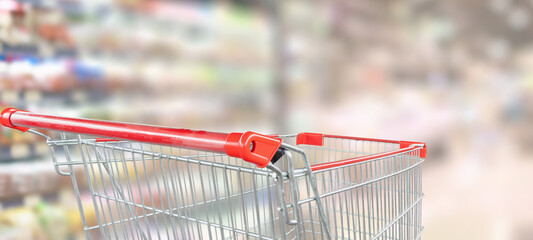 empty red shopping cart in supermarket aisle