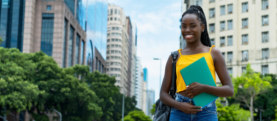 Pretty afro american female student with braids and backpack