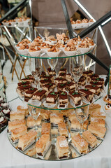 Sweet cakes at a wedding banquet. Catering, sweet festive buffet. Candy bar