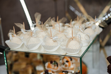 Sweet cakes at a wedding banquet. Catering, sweet festive buffet. Candy bar