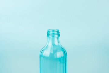 Blue glass bottle. Isolated on blue background. Concept of reusable containers