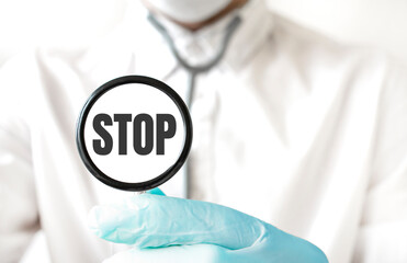 Doctor holding a stethoscope with text STOP, medical concept