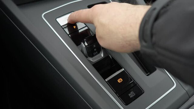Finger pushing start engine button in a brand new modern car. Close up