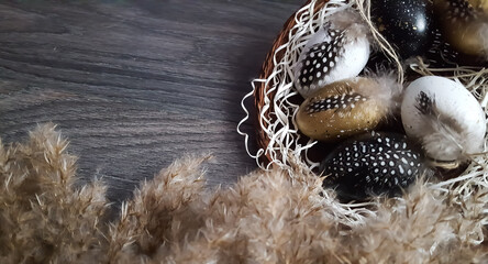 Easter composition of eggs in a wicker plate on a dark background with empty space. 