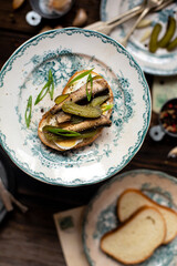 tasty open sandwiches with sprats, boiled eggs, onion on vintage plates. Russian cuisines