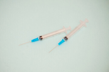 Two syringes close up isolated on a blue background