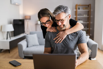 Happy Couple Looking At Laptop