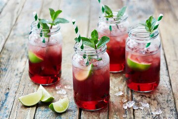 Still life with fruit cocktails in jars with drinking straws