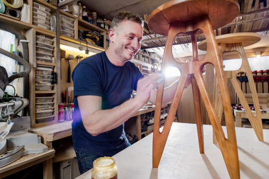 Craftsman polishing wooden stool with oil finish