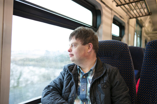 Man with down syndrome looking out of train window