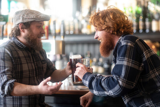 Two male customers making a toast in traditional Irish public house