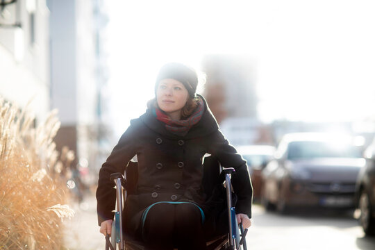 Woman in wheelchair in street