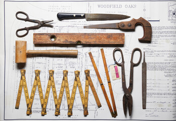Variety of vintage hand tools on property map, overhead view
