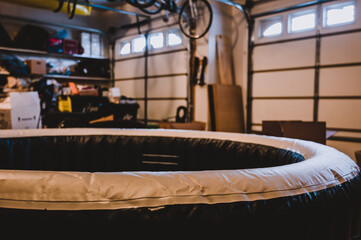 Filling an inflatable indoor hot tub inside a residential garage - obrazy, fototapety, plakaty