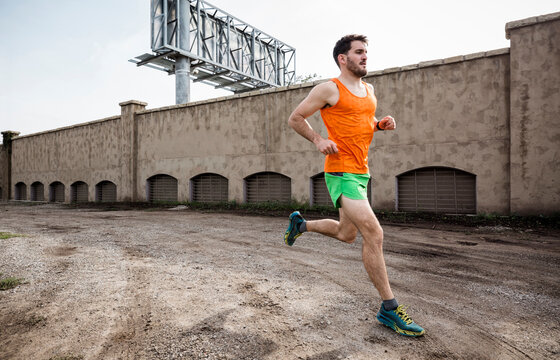 Young Male Runner Running On Urban Wasteland