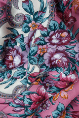 top view closeup on crumpled pink cotton scarf with bright floral ornament