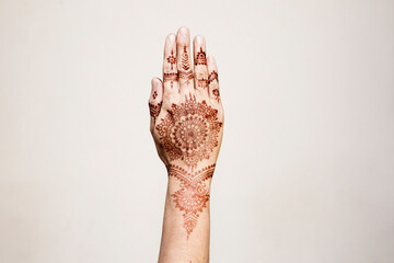 Hand with henna tattoo making gesture