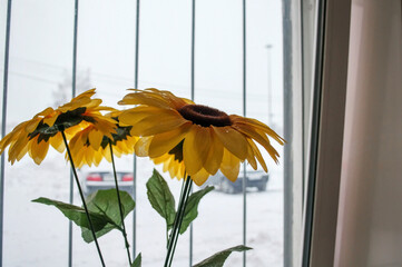 Artificial bouquet of flowers on the windowsill