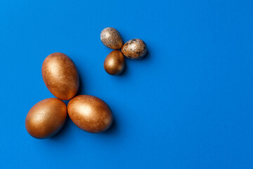 Golden modern easter eggs on a blue background. Easter concept. Isolated.