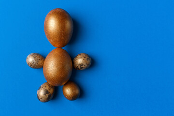 Golden modern easter eggs on a blue background. Easter concept. Isolated.