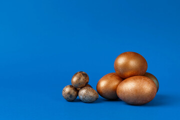 Golden modern easter eggs on a blue background. Easter concept. Isolated.