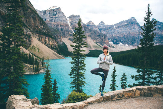 Woman practising yoga, Moraine Lake, Banff, Canada