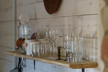 Country-style kitchen board wall with a shelf on which there are various glasses