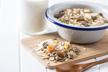Beakfast cereals on cutting board. Healthy muesli with oat flakes, nuts and raisins