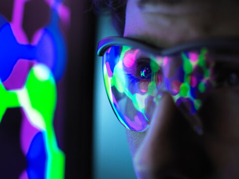 Student understanding the design of a molecular structure on computer screen in laboratory, close up