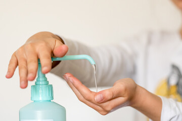 Fototapeta premium Enfant se lavant les mains acec du gel hydroalcoolique