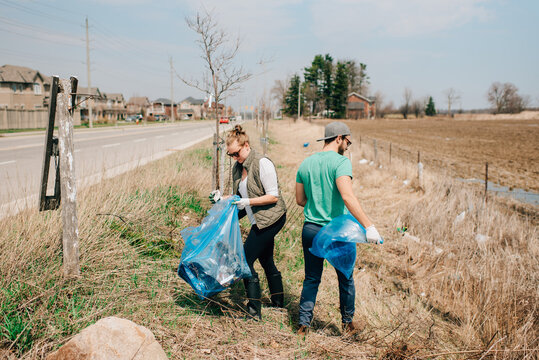 Couple picking up rubbish by roadside, Georgetown, Canada