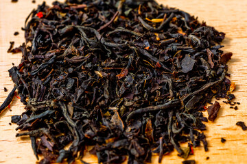 Delicious Black tea flavored with safflowers petals and bergamot pronounced taste. Selected focus Macro closeup photography of tea leaves background. Sharp and vivid colors, ideal for advertising