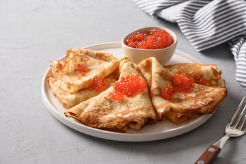 Russian thin pancakes or blini with red caviar. Shrovetide. Space for text. Close up.