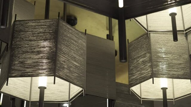 Low angle panning shot of illuminated pendant lights hanging at hotel - Suzhou, China