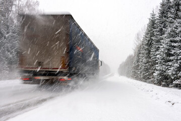 Blurred sketch with The truck in motion on road among the forest during a strong snow storm.