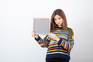 Photo of a young girl model standing and holding a frame